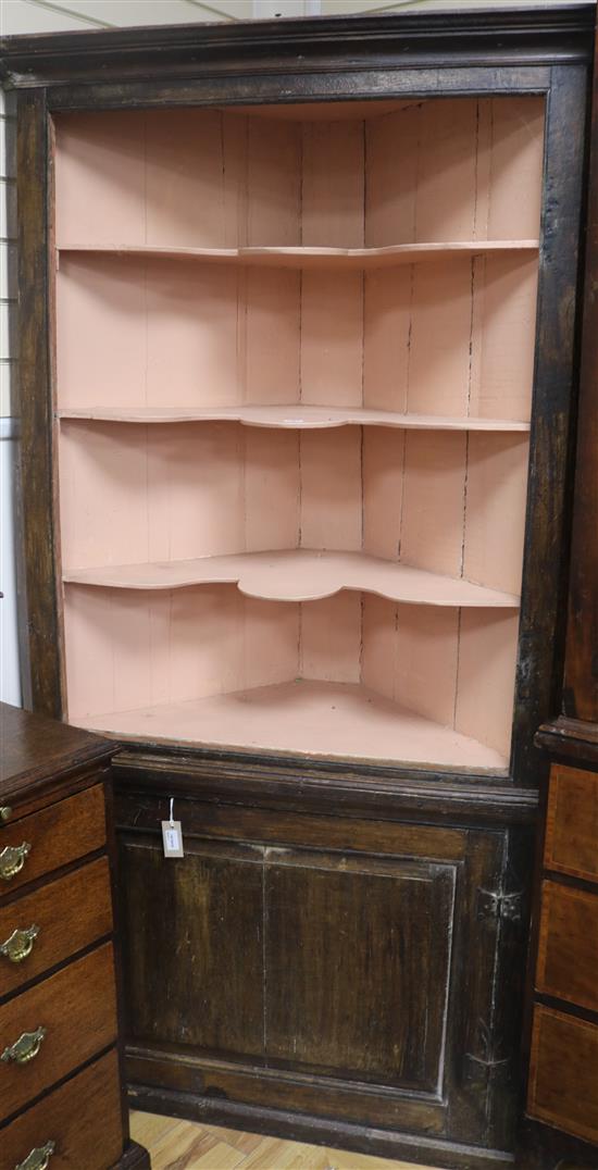 A Georgian oak standing corner open cabinet, with painted shelves and panelled door under, H.194cm